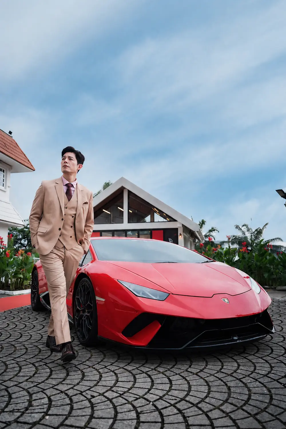 AIMS brand ambassador Zhang Yaodong in a tan suit beside a red Lamborghini